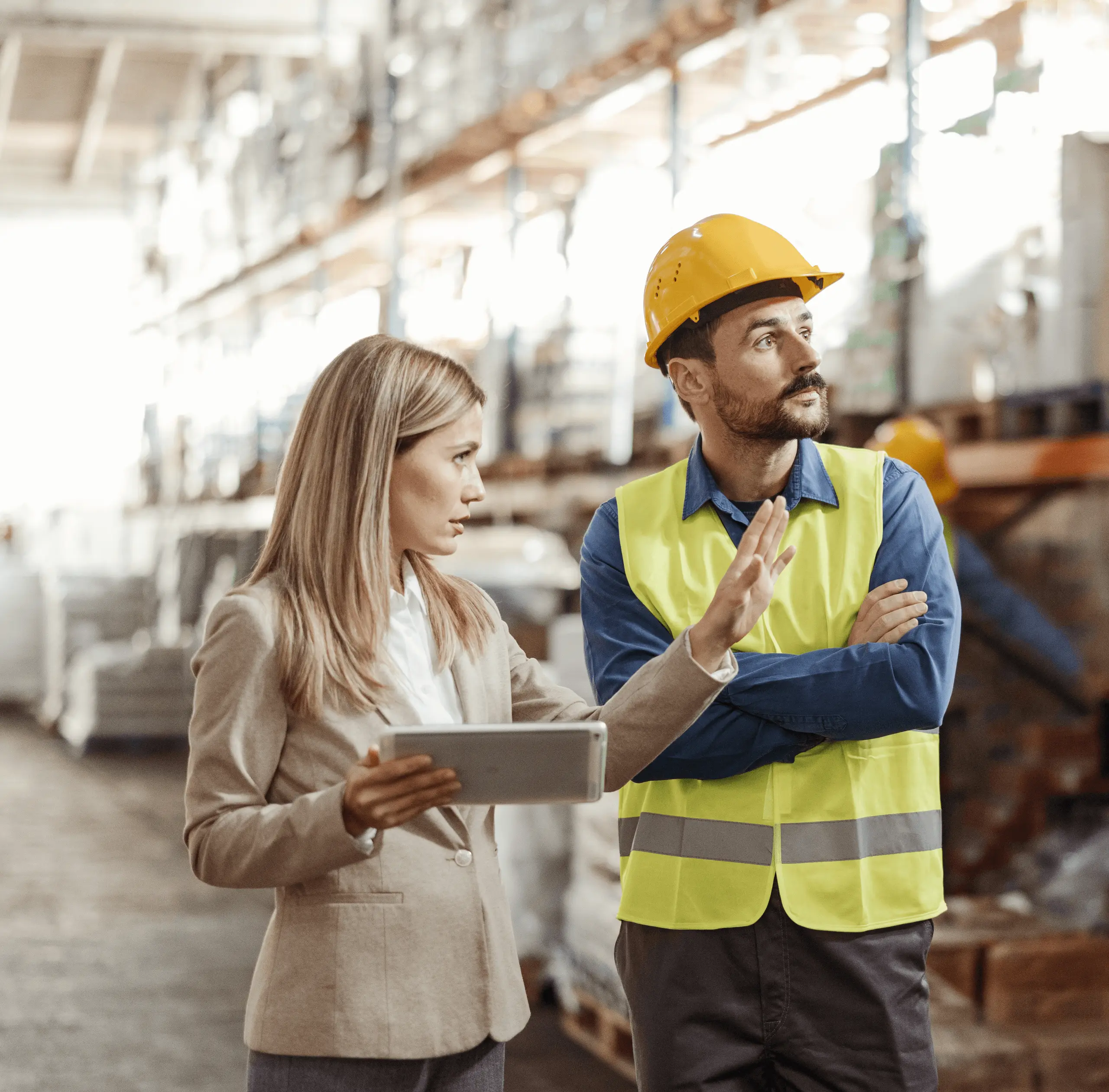 Manager and worker discussing clipboard in warehouse