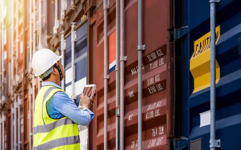 Worker inspecting shipping container