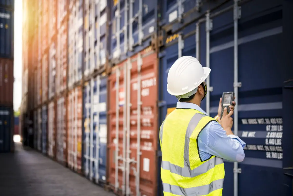 Worker photographing shipping containers
