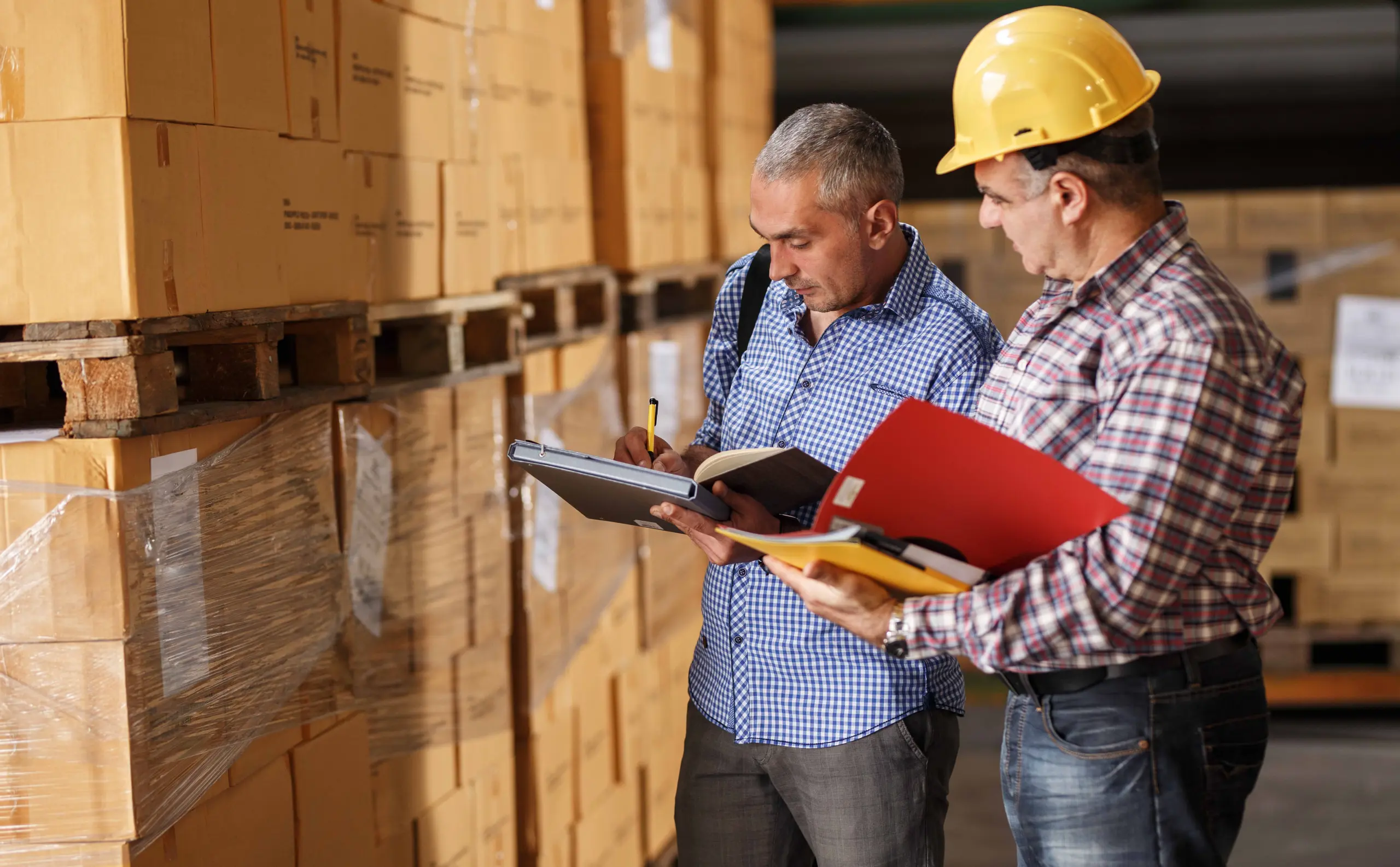 Two workers reviewing inventory in warehouse